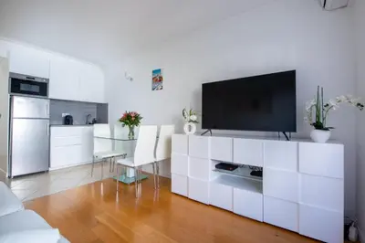 a living room with a white cabinet with a tv on it at Azur Central Flat in Nice