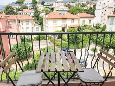 a wooden table and chairs sitting on a balcony at Lympia - one bedroom apartment near the port in Nice