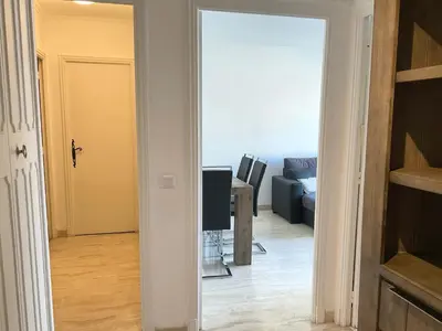 a hallway with a living room with a couch at Lympia - one bedroom apartment near the port in Nice