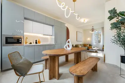 a kitchen and living room with a wooden table and bench at Nice Renting - 8BONAPARTE - Architect Loft Luxury 4 Bedrooms View Place du Pin in Nice