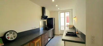 a kitchen with a black counter top and a sink at Appartement au coeur de la ville in Nice