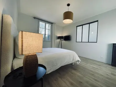 a bedroom with a bed and a table with a lamp at Appartement avec Terrasse - Palais Historique à Nice in Nice