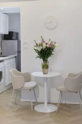 a vase of flowers on a white table in a kitchen at Magnifique appartement proche mer in Nice