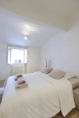 a white bedroom with a large bed with towels on it at Superbe appartement & proche mer in Nice