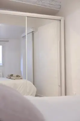 a white bedroom with a mirror and a bed at Superbe appartement & proche mer in Nice