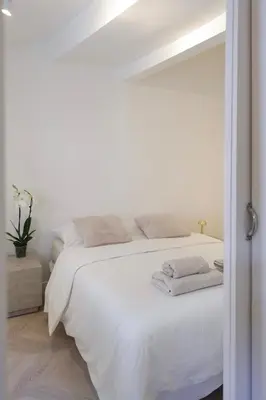 a white bedroom with a white bed with towels on it at Superbe appartement & proche mer in Nice
