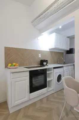 a white kitchen with a sink and a dishwasher at Superbe appartement & proche mer in Nice