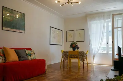 a living room with a red couch and a table and chairs at Riviera Prom 4 Pers Vista Mare in Nice