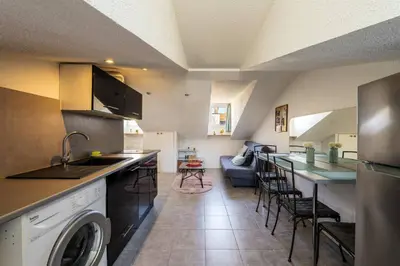 a kitchen with a washer and a living room at Perchoir dans la vieille ville in Nice