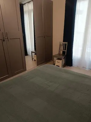 a bedroom with a green bed and a chair at Appart in Nice