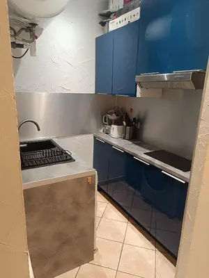 a small kitchen with blue cabinets and a sink at Appart in Nice