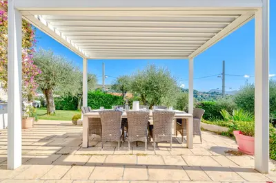 a white pergola with a table and chairs on a patio at Villa de prestige Vue mer panoramique Piscine Climatisation in Nice