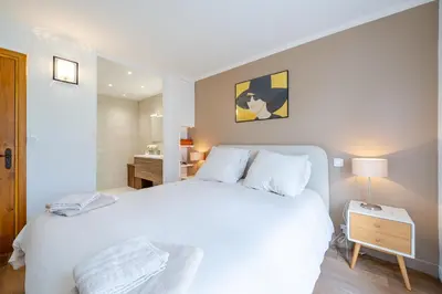 a bedroom with a large white bed with a night stand at Villa de prestige Vue mer panoramique Piscine Climatisation in Nice