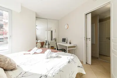a white bedroom with a bed and a desk at Nice Luxury in Nice