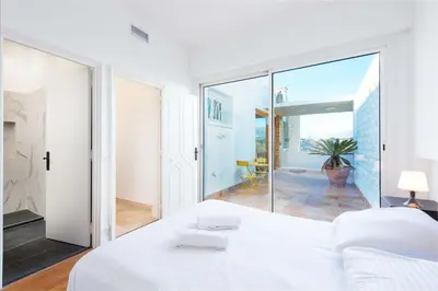 a bedroom with a large white bed and a balcony at Villa Grenouillere - Vue Mer - Fitness - Sauna in Cagnes-sur-Mer
