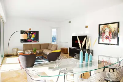 a living room with a glass table and a couch at Villa Grenouillere - Vue Mer - Fitness - Sauna in Cagnes-sur-Mer