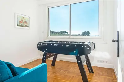 a piano in a living room with a blue couch and a window at Villa Grenouillere - Vue Mer - Fitness - Sauna in Cagnes-sur-Mer