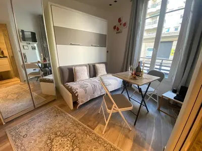 a living room with a bed and a table in a room at Cosy Studio Promenade in Nice