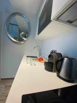a kitchen counter with a sink and a mirror at Cosy Studio Promenade in Nice