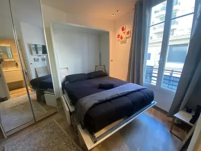 a bedroom with a bed and a large mirror at Cosy Studio Promenade in Nice