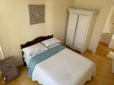 a bedroom with a bed and a cabinet at Appartement 3 pièces 5 min plage in Beaulieu-sur-Mer