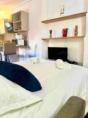 a large white bed with towels on top of it at Charmant studio Vieux Nice in Nice