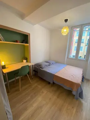 a bedroom with a bed and a desk and a table at Cosy Appartement Vieux Nice in Nice