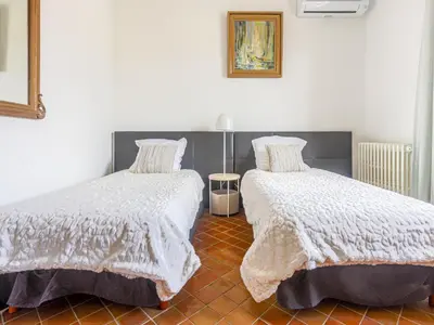 a bedroom with two beds with white comforters on them at Holiday Home Le Mas de Gattières by Interhome in Gattières