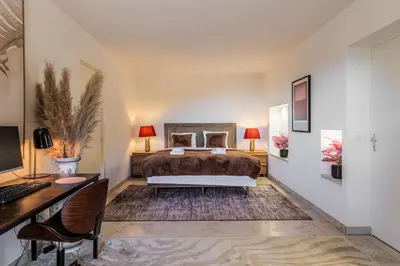 a bedroom with a bed and a desk with a computer at Elegance, serenite et vue exeptionnelle sur la rade in Villefranche-sur-Mer