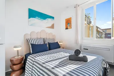 a bedroom with a bed with a blue and white comforter at Cocon Place Massena, Cours Saleya et Mer in Nice