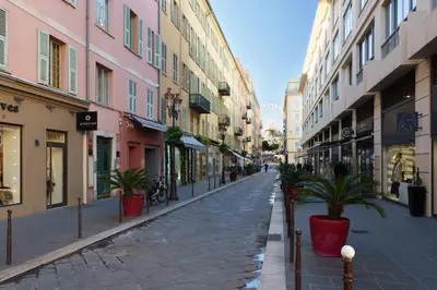 an empty street with potted plants and buildings at Cocon Place Massena, Cours Saleya et Mer in Nice
