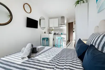 a bedroom with a bed with a blue and white blanket at Cocon Place Massena, Cours Saleya et Mer in Nice