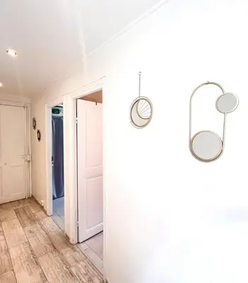 a hallway with white walls and two mirrors at Residence Lascaris in Nice