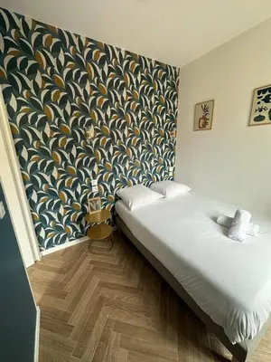 a bedroom with a bed with a patterned wall at Appartement 2 chb 1 SDB Nice - 32 in Nice