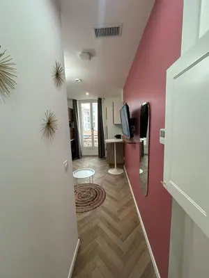 a hallway with a pink wall and a living room at MOON - 33 in Nice