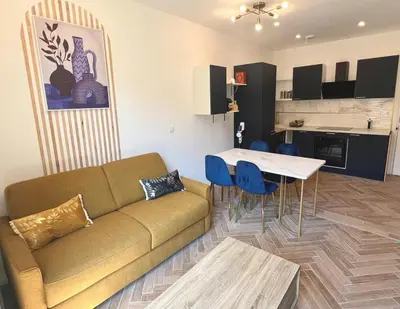 a living room with a couch and a table and a kitchen at MOON - 34 in Nice