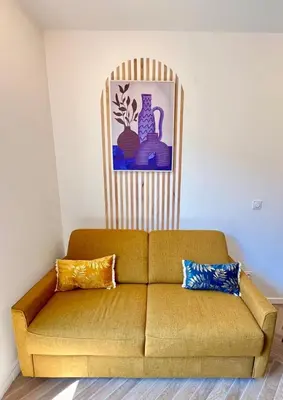 a couch with two pillows in a living room at MOON - 34 in Nice