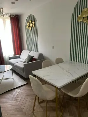 a living room with a table and a couch at MASSENA 36 in Nice