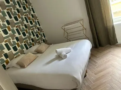 a bed with a white towel on it in a room at MASSENA 36 in Nice