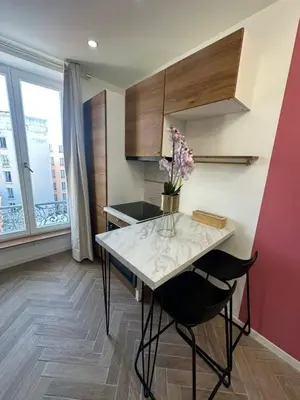 a kitchen with a table with a vase of flowers on it at MOON - 43 in Nice