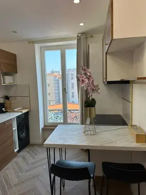 a kitchen with a table and chairs and a window at MOON - 43 in Nice