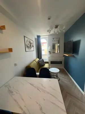 a living room with a table and a couch at MOON - 44 in Nice