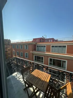 a balcony with a wooden table and chairs on a building at MOON - 44 in Nice