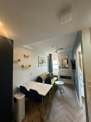 a living room with a table and a couch at MOON - 44 in Nice