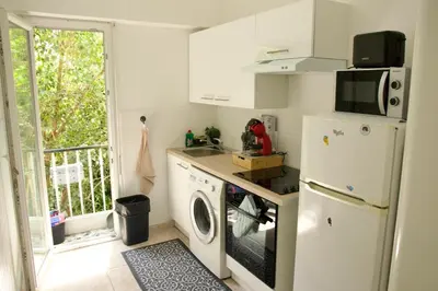 a kitchen with a refrigerator and a washing machine at Appartement à 5 min de la plage Soleil & Confort in Nice