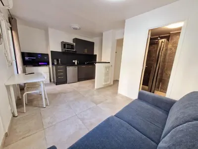 a living room with a blue couch and a table at appartement 2 pégurier in Nice