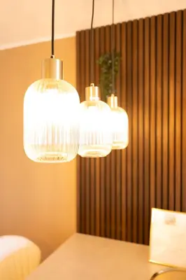 three lights hanging over a table in a room at Le Sunrise in Nice