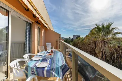 a balcony with a table and chairs on a balcony at Happyfew appartement les palmiers in Nice