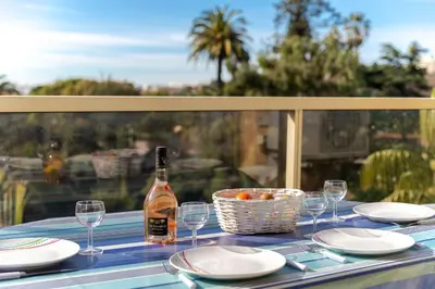 a table with a bottle of wine and glasses at Happyfew appartement les palmiers in Nice