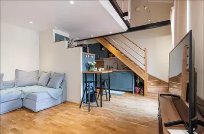 a living room with a blue couch and a staircase at Duplex center of Nice with AC in Nice